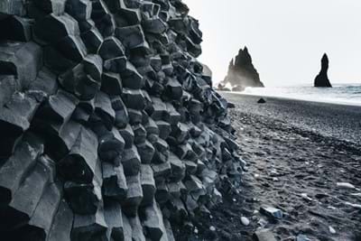 Reynisfjara black sand beach with huge stones in the water at dusk along the south coast of Iceland