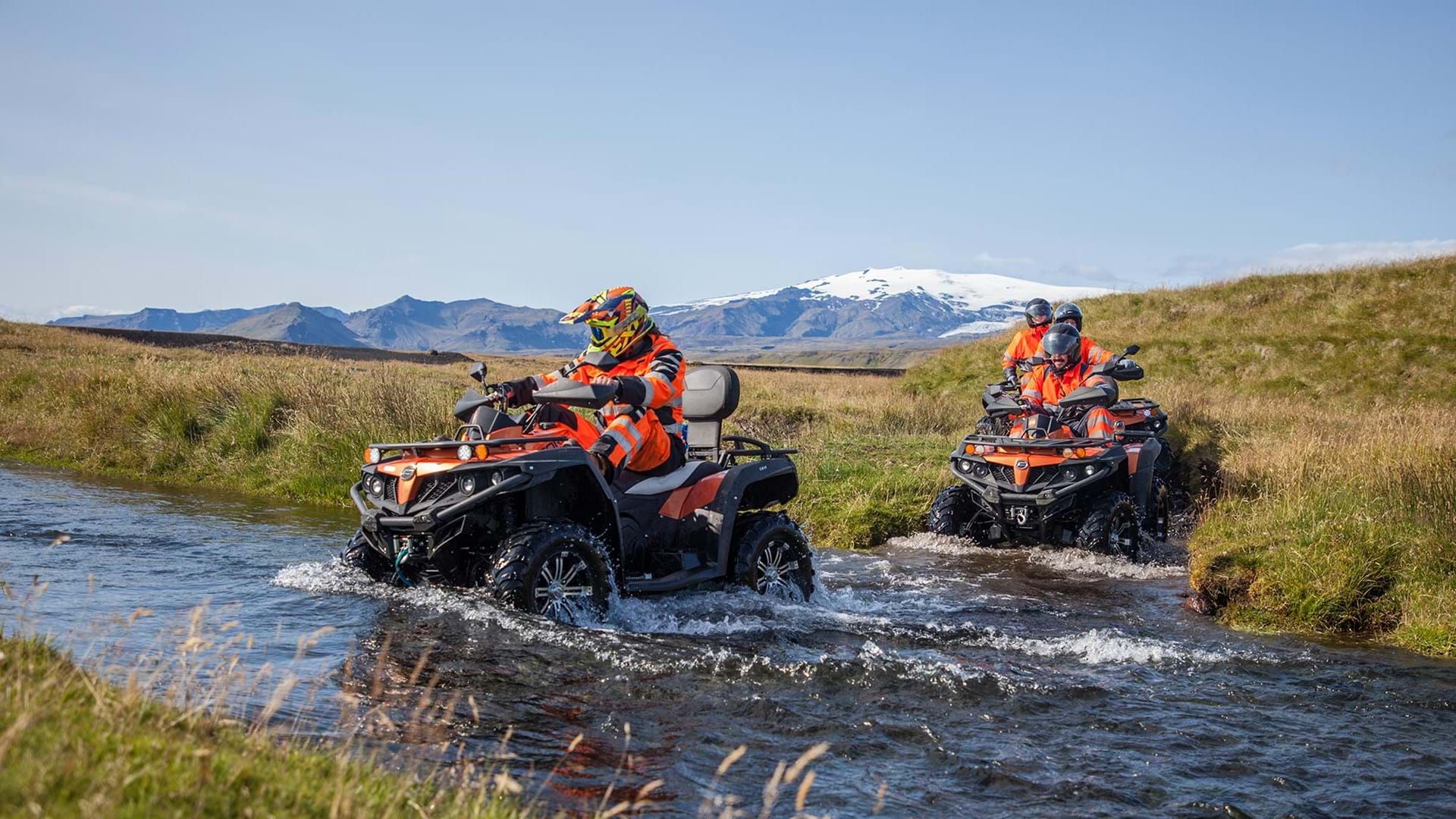 ATV guide crossing a small river with a group
