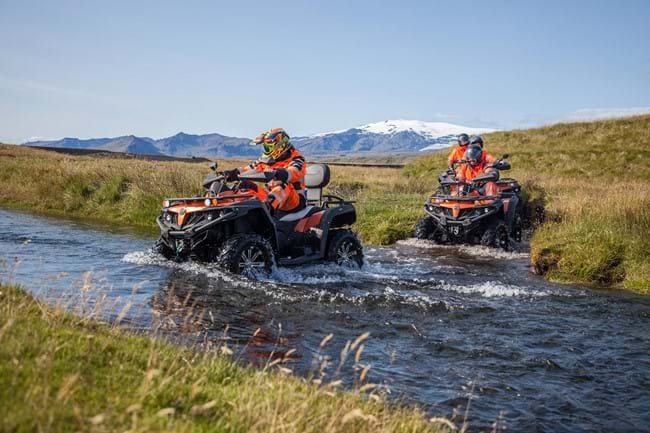 ATV guide crossing a small river with a group